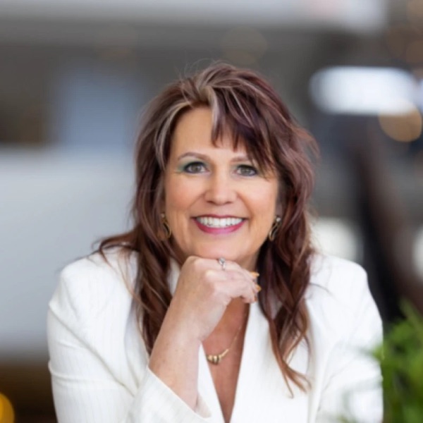 Melody Wilder smiling, in a white blazer