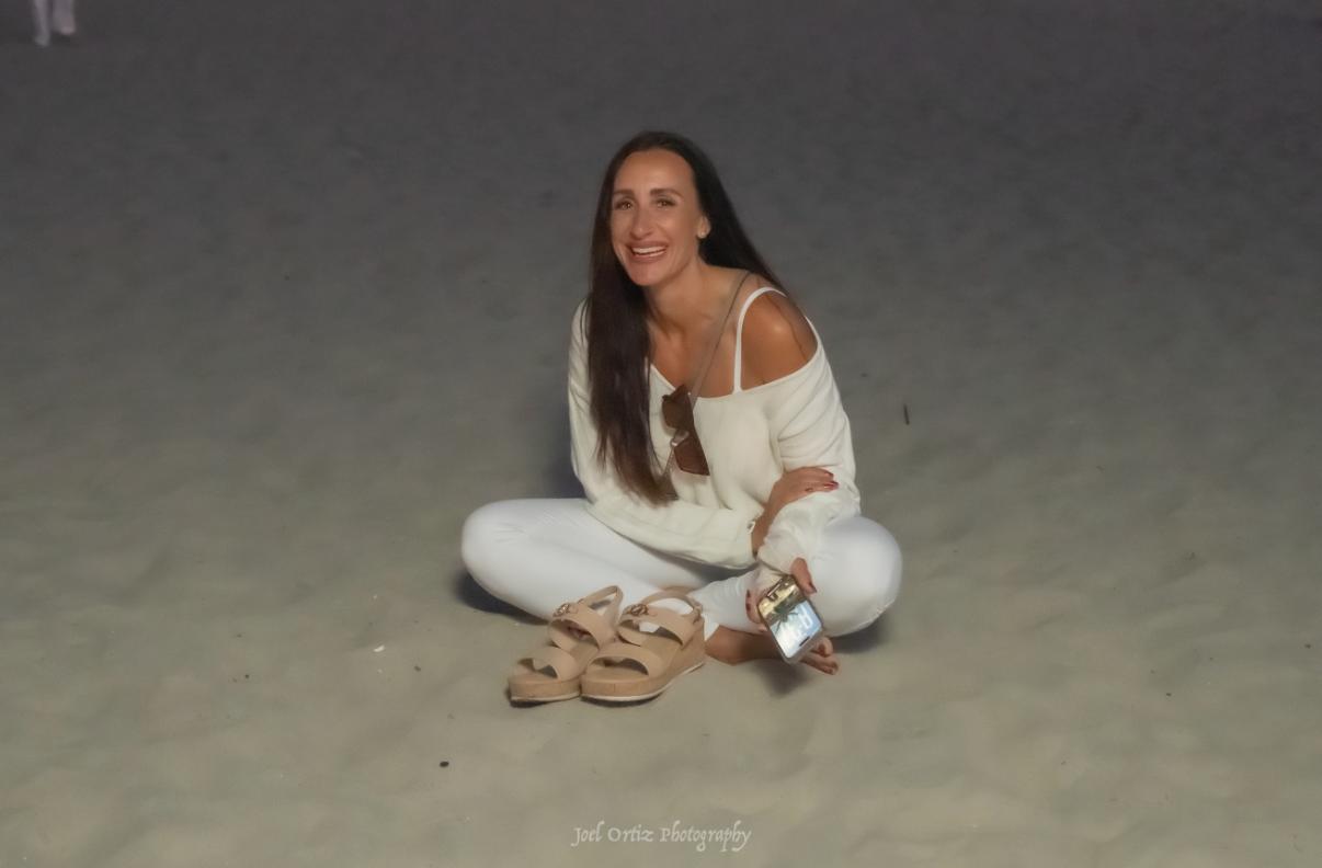 Jessica Wallace, smiling on the beach at dusk